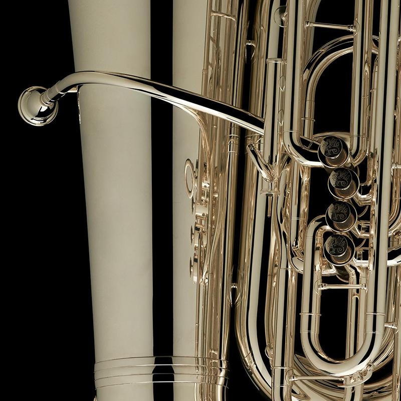 A close up image of the mouthpiece and detailed engravings on the valves of a BBb 6/4 Front-Piston Tuba "Grand" in silver from Wessex Tubas